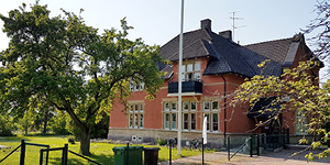 Bilden visar utsidan av fritidsgården Kvisten. Ett sekelskifteshus i roströd fasad. 