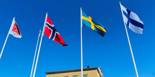 Norge, Sverige och Finlands flaggor på flaggstänger utanför stadshuset.