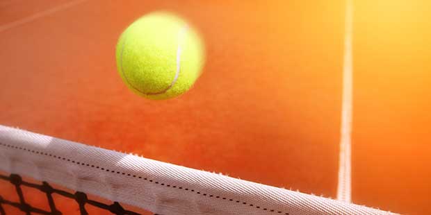 Tennisboll över nät på en tennisbana.