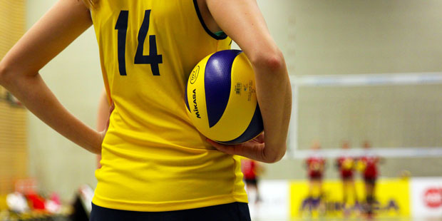 Volleybollspelare håller en volleyboll. 