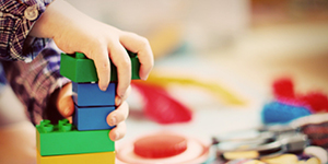 Bilden visar ett barn som leker med lego i olika färger