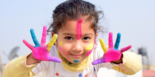 Bilden visar en flicka med färg på händerna 