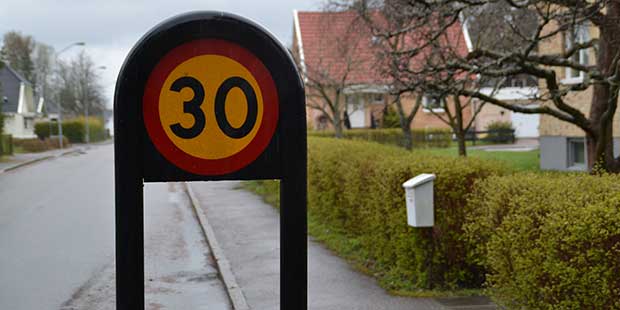 En skylt som visar hastighetsbegränsning 30 kilometer i timmen på en väg i ett bostadsområde.