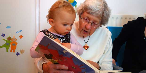 Ett barn och en äldre dam läser en bok